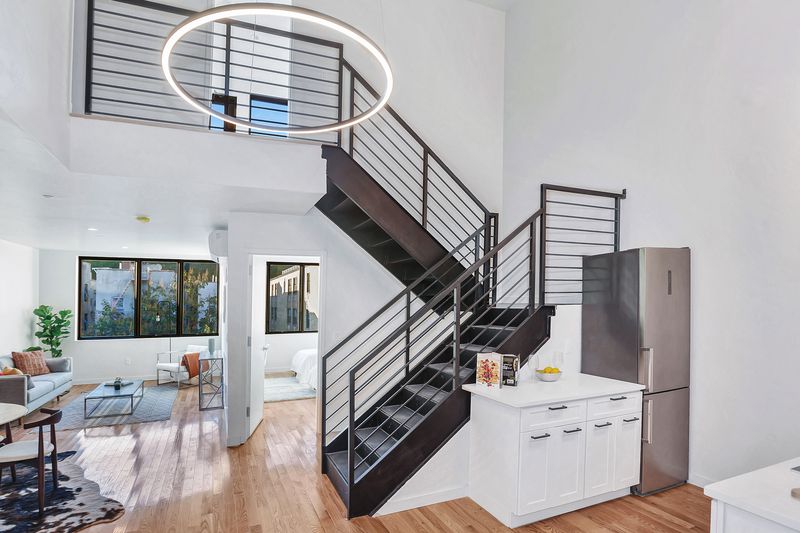 A living area with hardwood floors and a staircase that leads to a second level. 