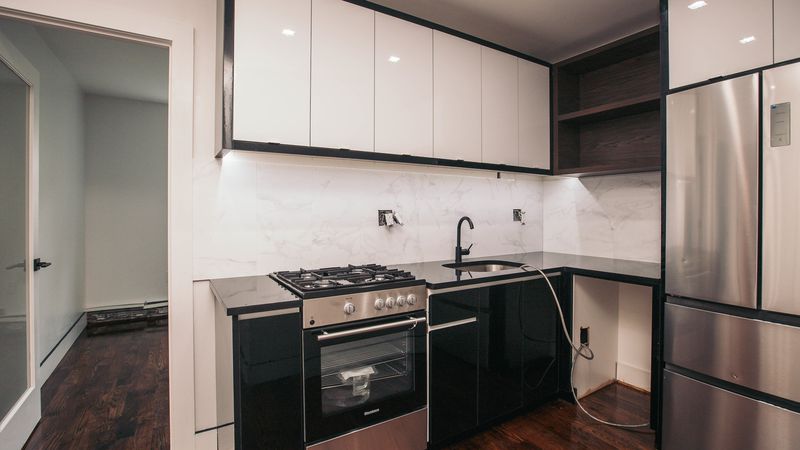 A kitchen with white and wooden cabinetry.