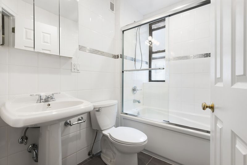 A bathroom with white tiles. 