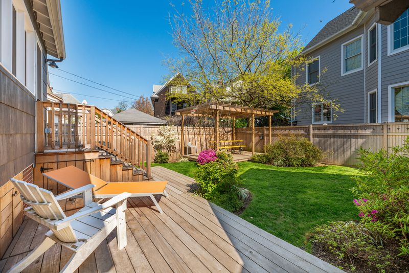 A landscaped backyard with wood fencing and several seating areas.