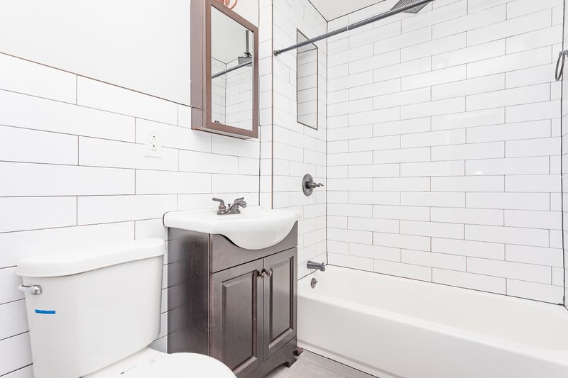 A bathroom with white tiles.