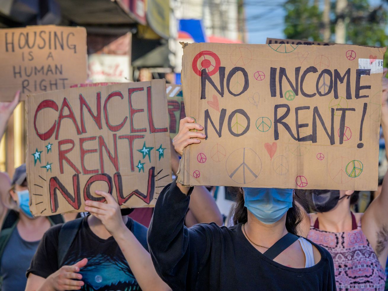 New Yorkers carrying signs painted with “Cancel Rent Now” and “No Income No Relief” during a Brooklyn protest.