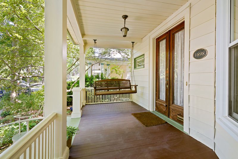 A porch with hardwood floors and a swing.