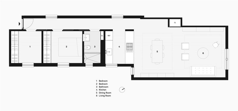 A floorplan showing a long hallway with two bedrooms, a bathroom, and kitchen, opening up to a large dining and living area.