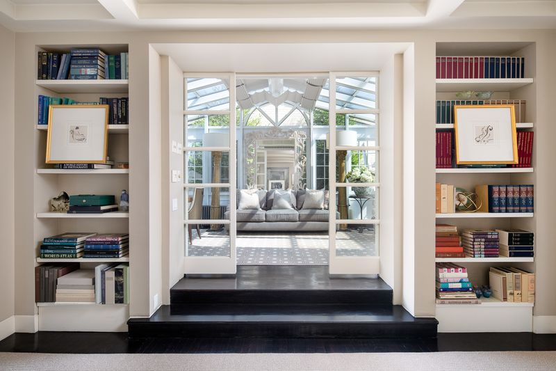 Built-in bookshelves flank sliding glass doors to a bright room.